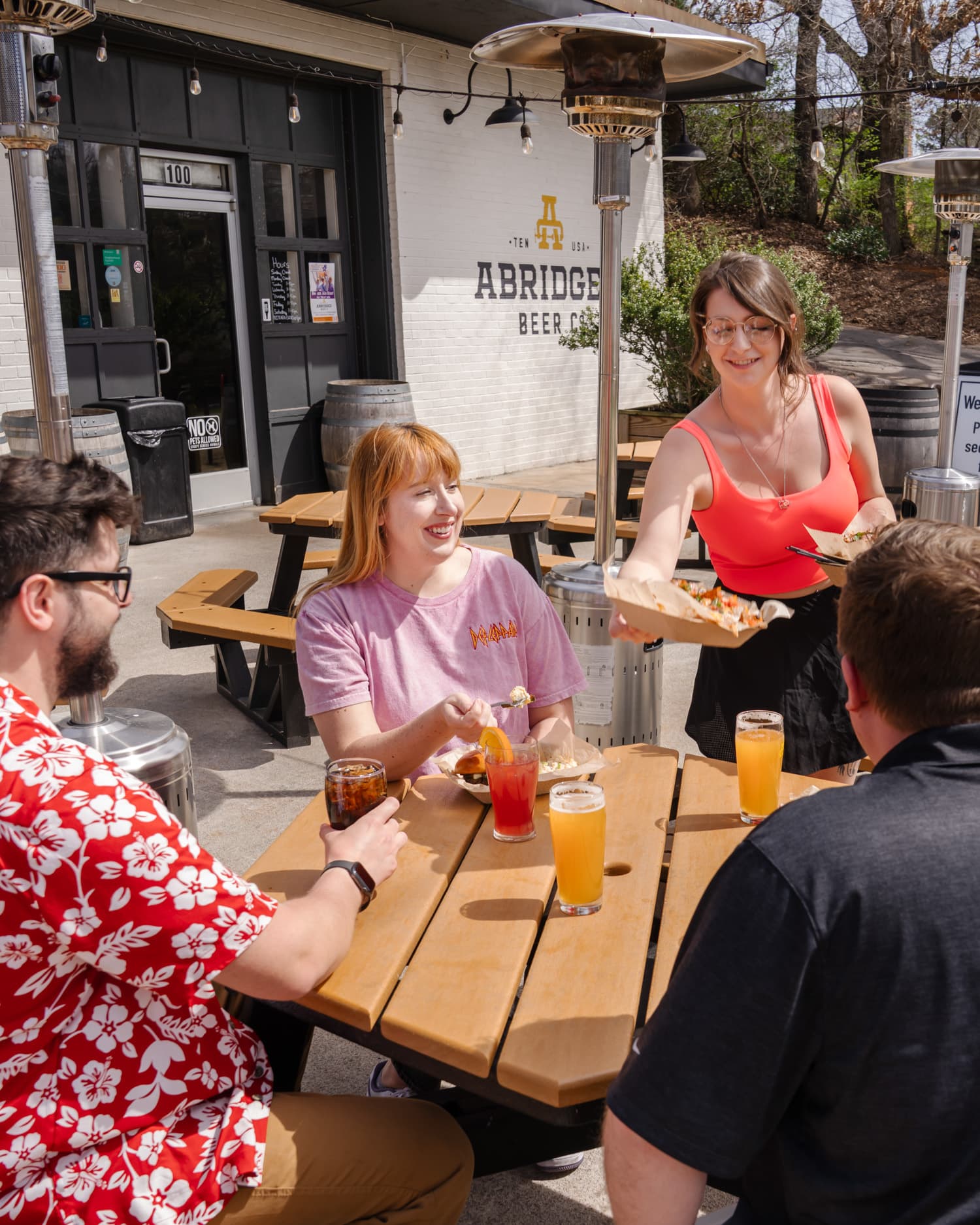 Friends enjoying food and drinks on the Abridged Beer Co patio